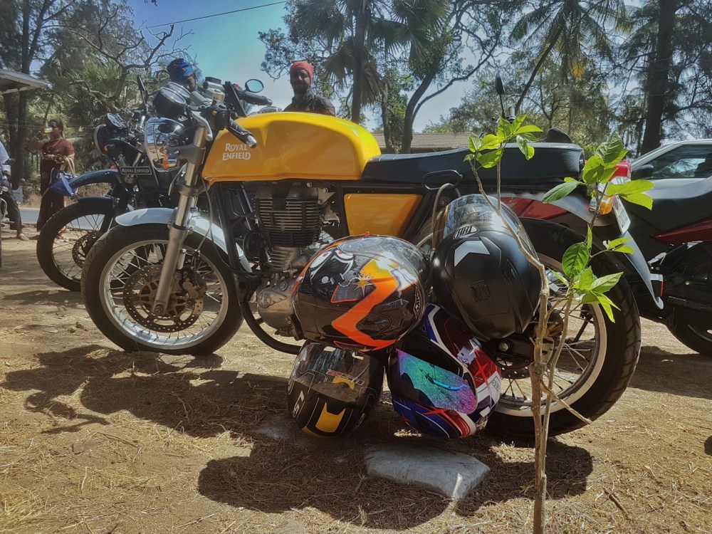Yellow Royal Enfield Continental GT parked along Dahanu Beach with helmets hanging - THH, MT, LD2 & SMK 